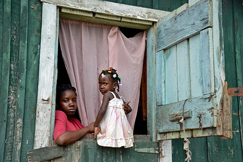 Mujer e hija en ventana en República Dominicana